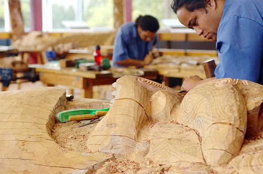 Māori students from The New Zealand Māori Arts & Crafts Institute in Rotorua making traditional Māori styled wood carvings.